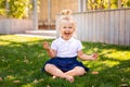 Cute adorable Caucasian toddler baby girl sitting and eating berries fruits. Funny child in park having healthy snack meal. Summer Royalty Free Stock Photo