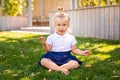 Cute adorable Caucasian toddler baby girl sitting and eating berries fruits. Funny child in park having healthy snack meal. Summer Royalty Free Stock Photo