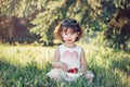 Cute adorable Caucasian toddler baby girl sitting on grass and eating red berries fruits. Funny child with sunglasses in park Royalty Free Stock Photo