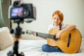 Cute adorable child blogger play guitar
