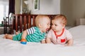 Cute adorable funny baby boys lying together on bed sharing toy Royalty Free Stock Photo