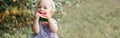 Cute adorable funny Caucasian baby girl eating ripe watermelon sitting on ground. Funny child kid with fresh red fruit outdoors in Royalty Free Stock Photo