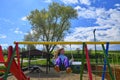 Cute adorable girl swinging on outdoor playground. Happy smiling girl child sitting in chain swing. Active girl on sunny Royalty Free Stock Photo