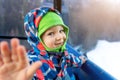 Cute adorable happy caucasian smiling toddler kid boy enjoy ascent sitting inside ski lift gondola cable car and giving