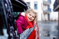 Cute adorable happy toddler girl sitting in car before leaving for winter vacations with parents. Little smiling child Royalty Free Stock Photo