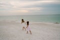 Cute Adorable Happy Young Little Girls in Pretty Dresses Playing On Vacation at the Tropical Beach by the Water on Destination Vac Royalty Free Stock Photo