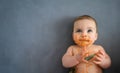 Cute adorable infant funny dirty baby trying to eat himself with fruit or vegetable puree smeared on his face. Baby Royalty Free Stock Photo