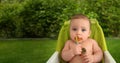 Cute adorable infant funny dirty baby trying to eat himself with fruit or vegetable puree smeared on his face. Baby Royalty Free Stock Photo