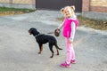 Cute adorable little blond caucasian kid girl walking with german terrier puppy dog on leash on sunny day. Animal domestic pet