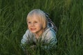 Cute adorable little caucasian kid toddler boy having fun lying on green grass lawn at home yard garden.Child on lawn in backyard Royalty Free Stock Photo