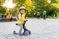 Cute adorable little caucasian toddler boy portrait in helmet having fun riding three-wheeled balance run bike scooter Royalty Free Stock Photo