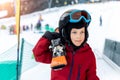 Cute adorable little kid boy enjoy having fun walking with ski on shoulder at alpine mountain skiing resort on bright Royalty Free Stock Photo