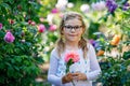 Cute adorable little preschool girl rose flower and princess dress in garden.. Portrait of smiling preschool child in Royalty Free Stock Photo