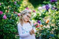 Cute adorable little preschool girl rose flower and princess dress in garden.. Portrait of smiling preschool child in Royalty Free Stock Photo