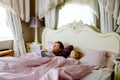 Cute adorable little toddler girl and father watching cartoons on laptop in bed. Tired baby child and man with tablet Royalty Free Stock Photo