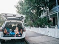Cute adorable little white Caucasian girl child sitting in open car trunk while travelling in Florida city town Key West. Royalty Free Stock Photo