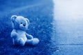 Cute adorable lost abandoned stuffed children toy teddy bear left on ground street road. Lost lonely toy outside. Concept of