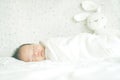 Cute adorable newborn baby boy wrapped or swaddle in a blanket, sleeping in kids bed