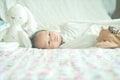 Cute adorable newborn baby boy wrapped or swaddle in a blanket, sleeping and sometime both eyes open in kids bed Royalty Free Stock Photo