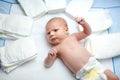 Cute adorable newborn baby on changing table with diapers. Cute little girl or boy looking at the camera. Dry and Royalty Free Stock Photo