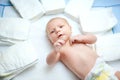 Cute adorable newborn baby on changing table with diapers. Cute little girl or boy looking at the camera. Dry and Royalty Free Stock Photo