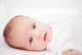 Cute adorable newborn baby girl in white bed and looking at the camera Royalty Free Stock Photo