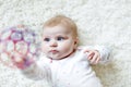 Cute adorable newborn baby playing with colorful ball toy on white background. New born child, little girl looking at Royalty Free Stock Photo