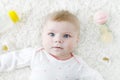 Cute baby girl playing with colorful pastel rattle toy, nursing bottle and dummy Royalty Free Stock Photo