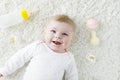 Cute adorable newborn baby playing with colorful pastel rattle toy, nursing milk bottle and dummy. New born child Royalty Free Stock Photo