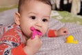 Cute adorable newborn baby playing with colorful rattle toy. baby with teether. six months old lovely baby portrait on Royalty Free Stock Photo