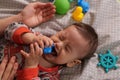 Cute adorable newborn baby playing with colorful rattle toy. baby with teether. six months old lovely baby portrait on Royalty Free Stock Photo