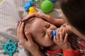 Cute adorable newborn baby playing with colorful rattle toy. baby with teether. six months old lovely baby portrait on Royalty Free Stock Photo