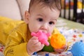 Cute adorable newborn baby playing with colorful rattle toy. baby with teether. six months old lovely baby portrait on Royalty Free Stock Photo