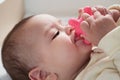 Cute adorable newborn baby playing with colorful rattle toy. baby with teether. six months old lovely baby portrait on Royalty Free Stock Photo