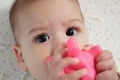 Cute adorable newborn baby playing with colorful rattle toy. baby with teether. six months old lovely baby portrait on Royalty Free Stock Photo