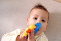 Cute adorable newborn baby playing with colorful rattle toy. baby with teether. six months old lovely baby portrait on Royalty Free Stock Photo