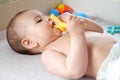 Cute adorable newborn baby playing with colorful rattle toy. baby with teether. six months old lovely baby portrait on Royalty Free Stock Photo