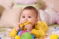 Cute adorable newborn baby playing with colorful rattle toy. baby with teether. six months old lovely baby portrait on Royalty Free Stock Photo