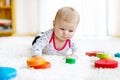 Cute baby girl playing with colorful wooden rattle toy Royalty Free Stock Photo