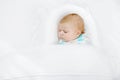 Cute adorable newborn baby wrapped in white blanket, sleeping in kids bed or cocoon. Closeup of peaceful child, little Royalty Free Stock Photo