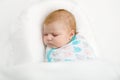 Cute adorable newborn baby wrapped in white blanket, sleeping in kids bed or cocoon. Closeup of peaceful child, little Royalty Free Stock Photo