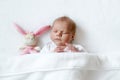 Cute adorable peaceful newborn baby sleeping in white bed. New born child, little girl six days old laying in bed Royalty Free Stock Photo
