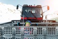 Cute adorable playful happy toddler boy inside red modern snowcat ratrack snowplow box grooming standing on peak alpine Royalty Free Stock Photo