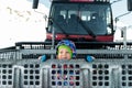 Cute adorable playful happy toddler boy inside red modern snowcat ratrack snowplow box grooming standing on peak alpine Royalty Free Stock Photo