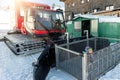 Cute adorable playful happy toddler boy inside red modern snowcat ratrack snowplow box grooming standing on peak alpine Royalty Free Stock Photo