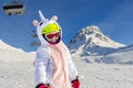 Cute adorable preschooler caucasian kid girl portrait with ski in helmet, goggles and unicorn fun costume enjoy winter sport