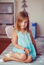 Cute adorable pretty dressed preschool girl playing a fairy princess at home. Child creativity imagination and fantasy dreams