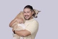 Cute and adorable scene of a man carrying around his spoiled mid-sized adult dog on his shoulders. on a white background