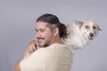 Cute and adorable scene of a man carrying around his spoiled mid-sized adult dog on his shoulders. Isolated on a white background
