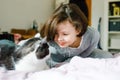 Cute adorable school kid girl cuddling and playing together with cat in bed in morning. Happy family, friendship between Royalty Free Stock Photo